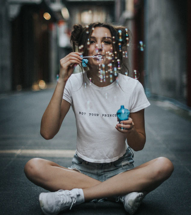 Woman sitting down and blowing bubbles